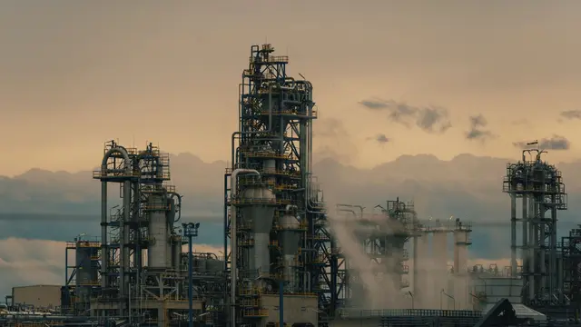 Refinery towers against a cloudy dusk sky