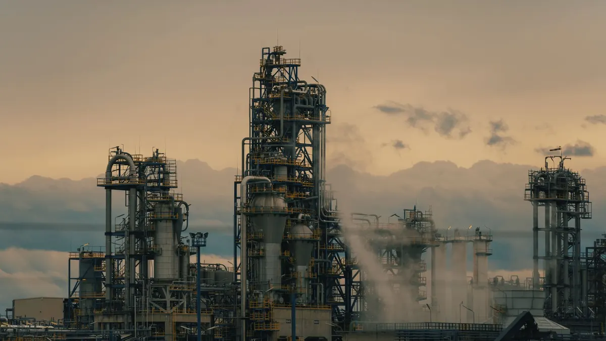 Refinery towers against a cloudy dusk sky